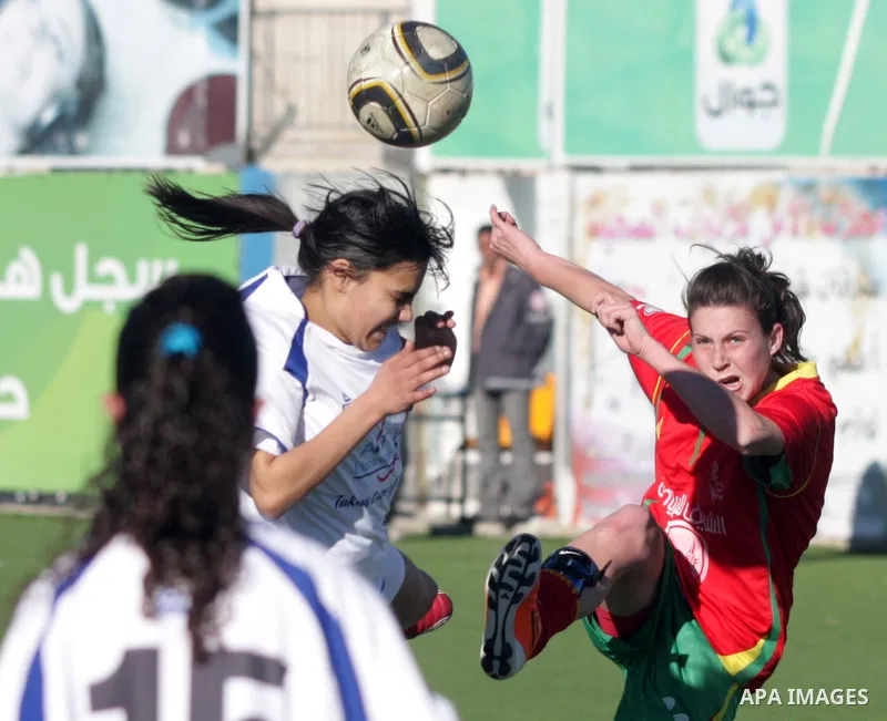 Palestinians play a football match between Deyaar team (red) and Al-Rwaa team (white) in the West Bank city of Bethlehem on Feb. 18, 2011. Within the Premier League for females at the Al-Khader Stade. Photo by Najeh Hash...