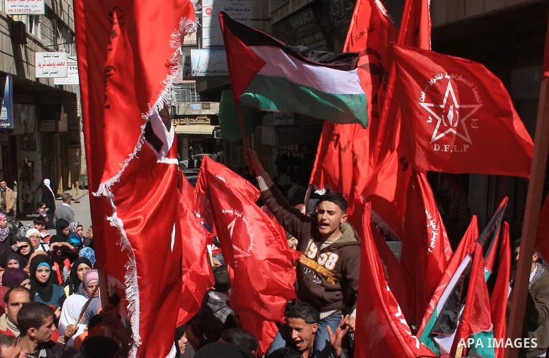 Palestinian youth waves the national flag during a demonstration calling to end the split between the West Bank and Gaza, marking the 42th anniversary of the Democratic Front for the Liberation of Palestine (DFLP) in the...