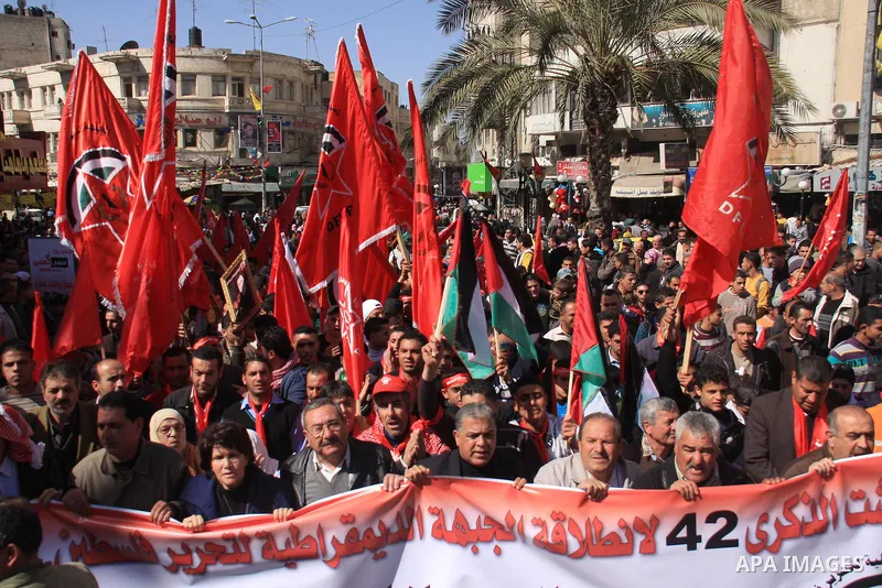 Palestinians take part during a demonstration calling to end the split between the West Bank and Gaza, marking the 42th anniversary of the Democratic Front for the Liberation of Palestine (DFLP) in the West Bank city of...