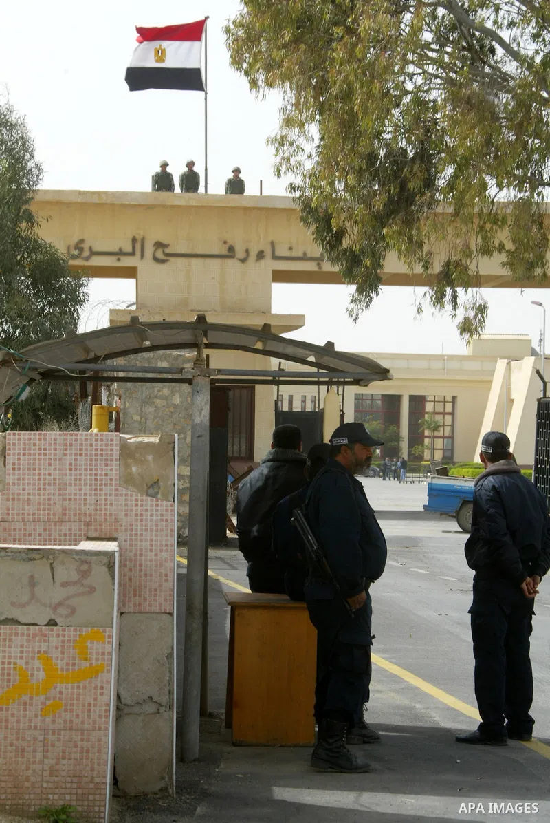 Egyptian soldiers (top) keep watch on the Egyptian side of the Rafah border crossing as Hamas policemen stand guard on the Palestinian side on February 19, 2011. The Egyptian authorities reopened the Rafah crossing on it...