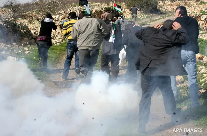 Israeli soldiers fire tear gas towards Palestinian ,Israeli and International protesters during a demonstration against the demolishing of farm land to be used in the construction of Jewish settlements near the existing...