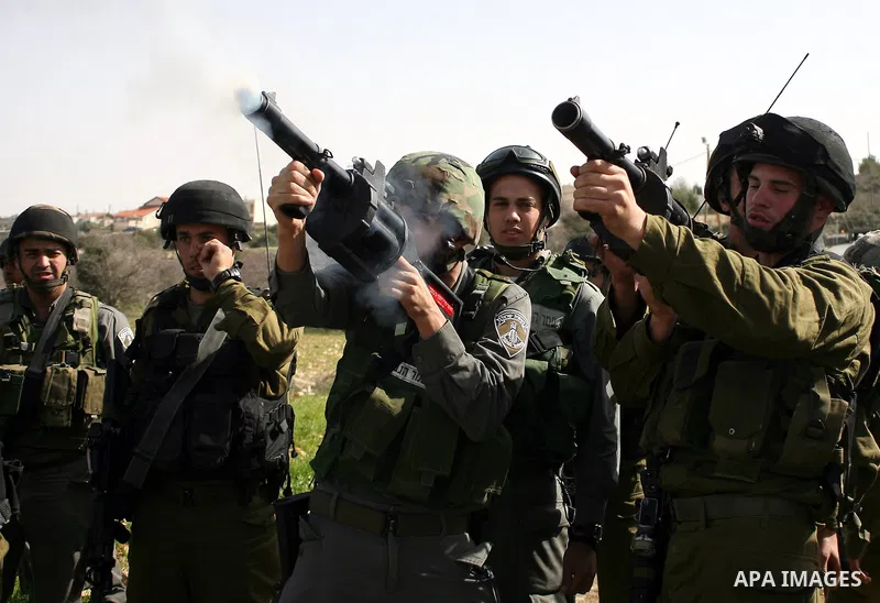 Israeli soldiers fire tear gas towards Palestinian ,Israeli and International protesters during a demonstration against the demolishing of farm land to be used in the construction of Jewish settlements near the existing...