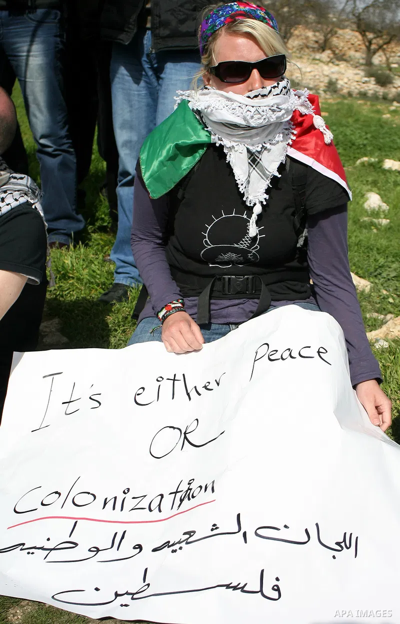 Palestinian, Israeli and foreign activists take part in a demonstration against the demolishing of farm land to be used in the construction of Jewish settlements near the existing Israeli settlement of Karmi Tsor near th...