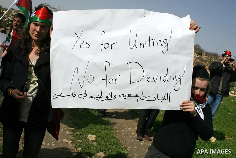 Palestinian, Israeli and foreign activists take part in a demonstration against the demolishing of farm land to be used in the construction of Jewish settlements near the existing Israeli settlement of Karmi Tsor near th...