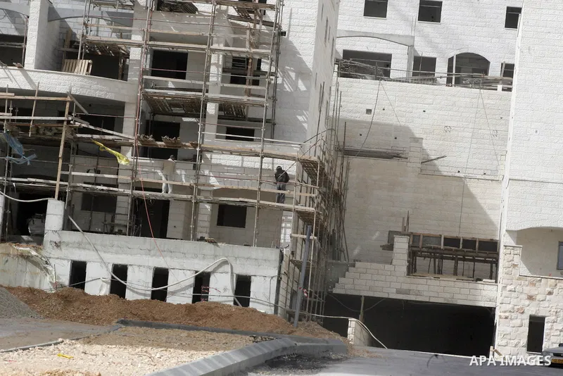 Palestinian labourers work at a construction site at the Jewish settlement in Harmoun Hanatsev in the east Jerusalem Feb. 20,2011. The United States vetoed a resolution that received 14 votes in favour from the United Na...
