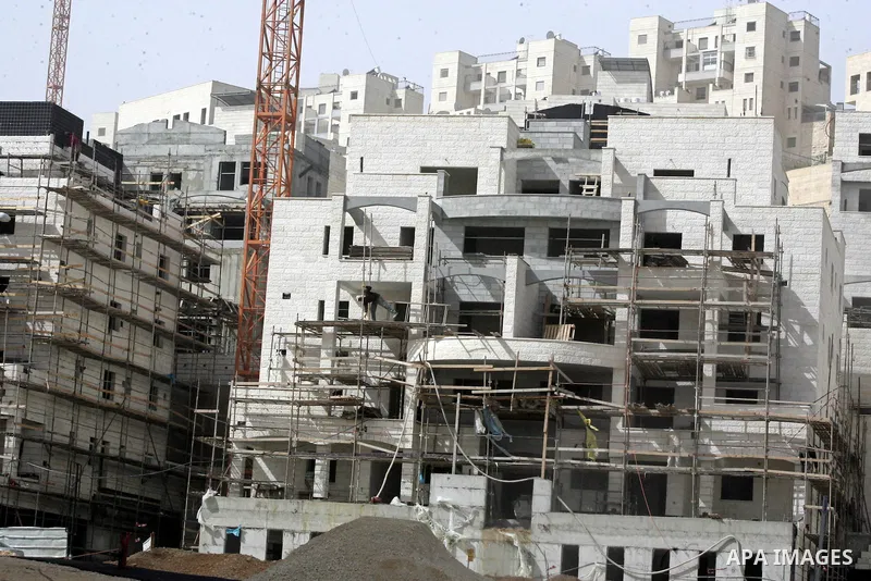 Palestinian labourers work at a construction site at the Jewish settlement in Harmoun Hanatsev in the east Jerusalem Feb. 20,2011. The United States vetoed a resolution that received 14 votes in favour from the United Na...