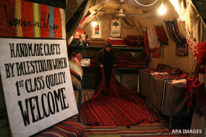Palestinians shop in a traditional market at the old city in the West Bank city of Hebron on February 20, 2011. Photo by Najeh Hashlamoun