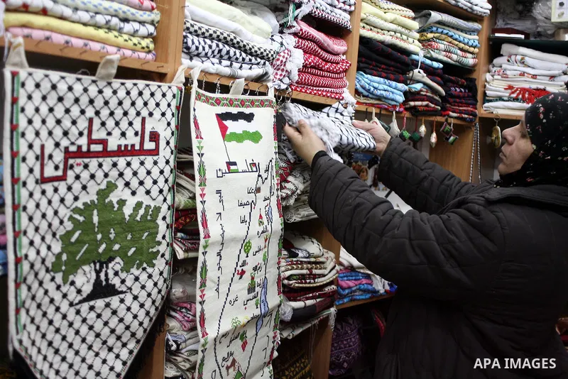 Palestinians shop in a traditional market at the old city in the West Bank city of Hebron on February 20, 2011. Photo by Najeh Hashlamoun