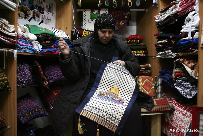 Palestinians shop in a traditional market at the old city in the West Bank city of Hebron on February 20, 2011. Photo by Najeh Hashlamoun