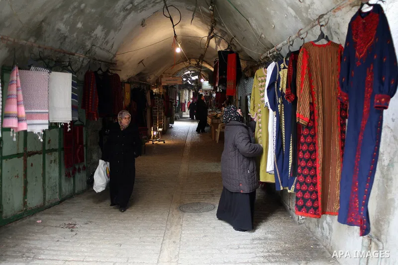 Palestinians shop in a traditional market at the old city in the West Bank city of Hebron on February 20, 2011. Photo by Najeh Hashlamoun