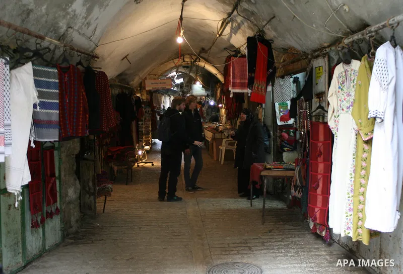 Foreigners shop in a traditional market at the old city in the West Bank city of Hebron on February 20, 2011. Photo by Najeh Hashlamoun