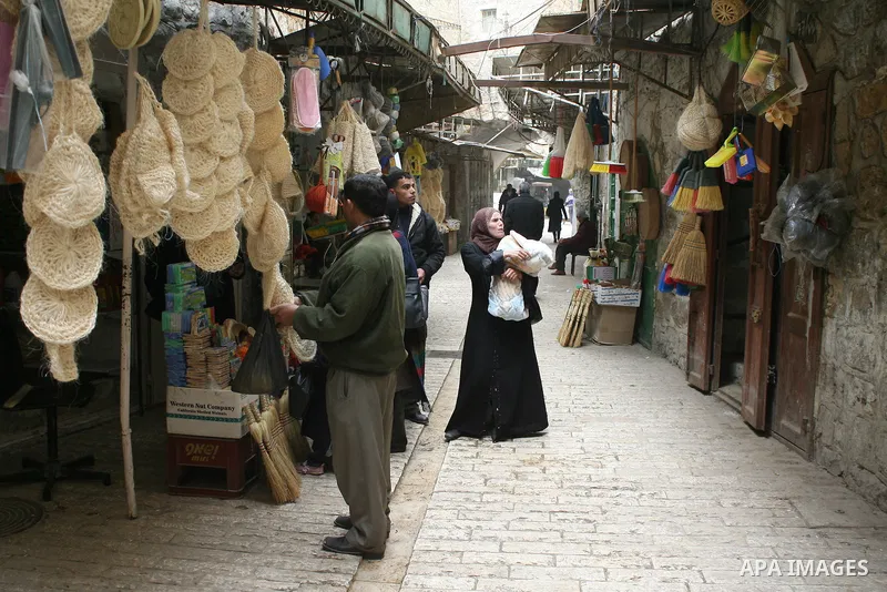 Palestinians shop in a traditional market at the old city in the West Bank city of Hebron on February 20, 2011. Photo by Najeh Hashlamoun