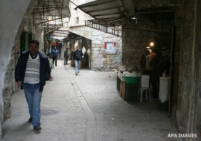 Palestinians shop in a traditional market at the old city in the West Bank city of Hebron on February 20, 2011. Photo by Najeh Hashlamoun