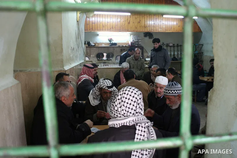 Palestinians sit in a coffee shop in a traditional market at the old city in the West Bank city of Hebron on February 20, 2011. Photo by Najeh Hashlamoun