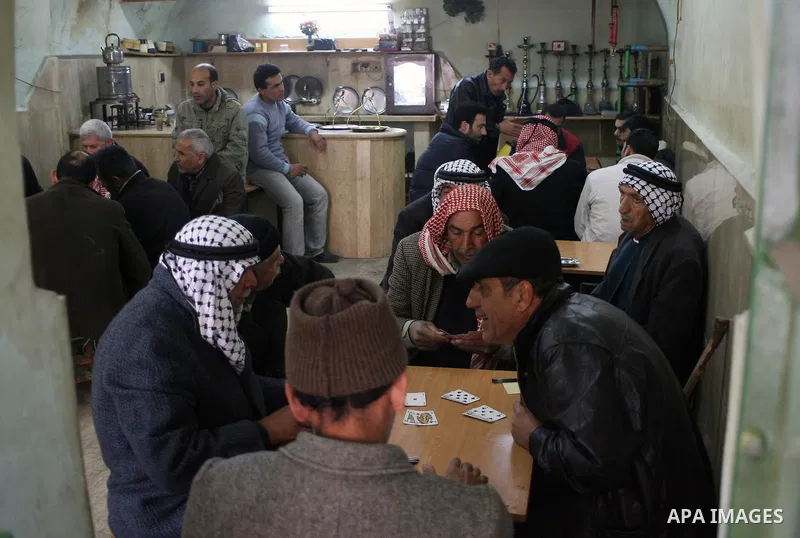 Palestinians sit in a coffee shop in a traditional market at the old city in the West Bank city of Hebron on February 20, 2011. Photo by Najeh Hashlamoun