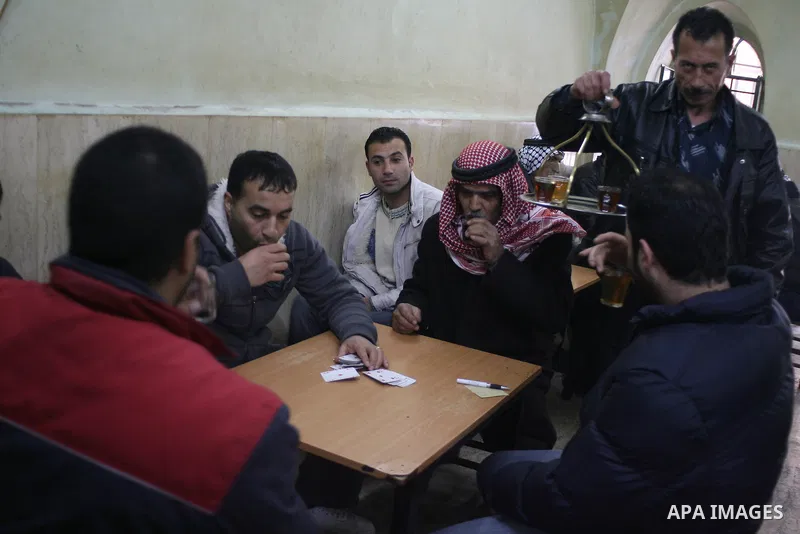 Palestinians sit in a coffee shop in a traditional market at the old city in the West Bank city of Hebron on February 20, 2011. Photo by Najeh Hashlamoun