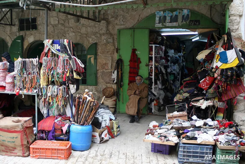 Palestinians shop in a traditional market at the old city in the West Bank city of Hebron on February 20, 2011. Photo by Najeh Hashlamoun