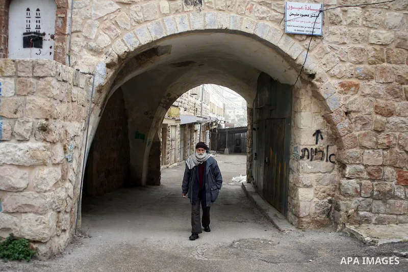 Palestinians shop in a traditional market at the old city in the West Bank city of Hebron on February 20, 2011. Photo by Najeh Hashlamoun