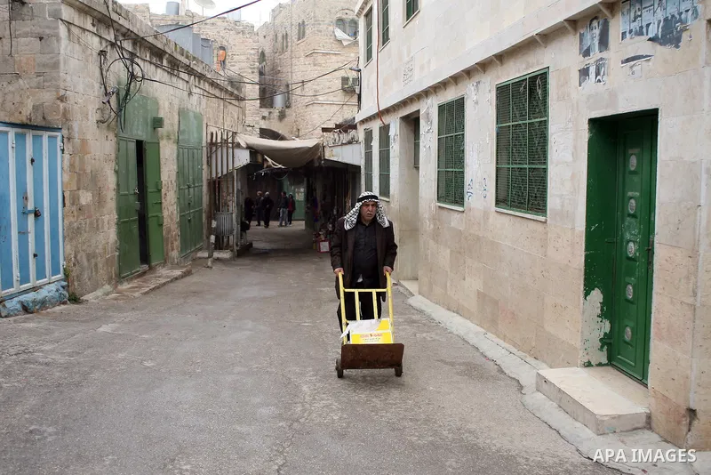 Palestinians shop in a traditional market at the old city in the West Bank city of Hebron on February 20, 2011. Photo by Najeh Hashlamoun