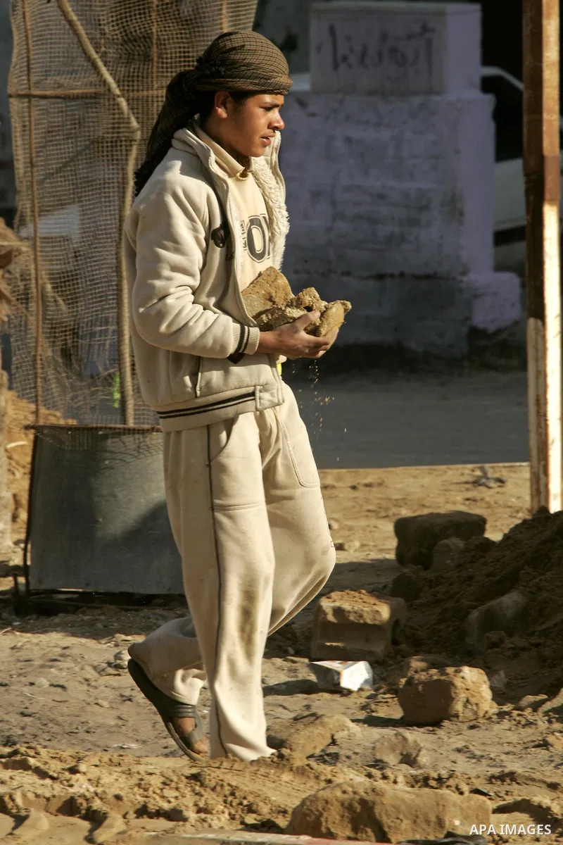 A Palestinian boy extracts the stone from the sand, To re-manufacture a new block in the Rafah refugee camp southern Gaza Strip on February 21, 2011. Because of the Israeli siege and closure of the crossings and prevent...