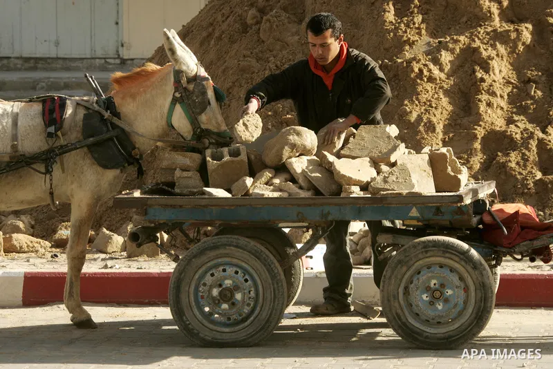A Palestinian boy extracts the stone from the sand, To re-manufacture a new block in the Rafah refugee camp southern Gaza Strip on February 21, 2011. Because of the Israeli siege and closure of the crossings and prevent...