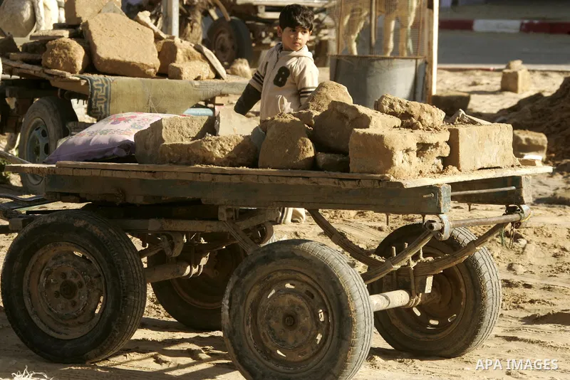 A Palestinian boy extracts the stone from the sand, To re-manufacture a new block in the Rafah refugee camp southern Gaza Strip on February 21, 2011. Because of the Israeli siege and closure of the crossings and prevent...