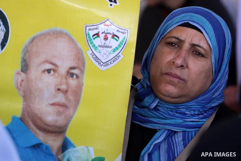 A Palestinian woman holds a picture of jailed relative during a protest calling for the release of Palestinian prisoners from Israeli jails at the Red Cross office in Gaza City on Feb. 21, 2011. Photo by Mohammed Asad