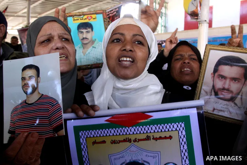 Palestinian women hold pictures of jailed relatives during a protest calling for the release of Palestinian prisoners from Israeli jails at the Red Cross office in Gaza City on Feb. 21, 2011. Photo by Mohammed Asad