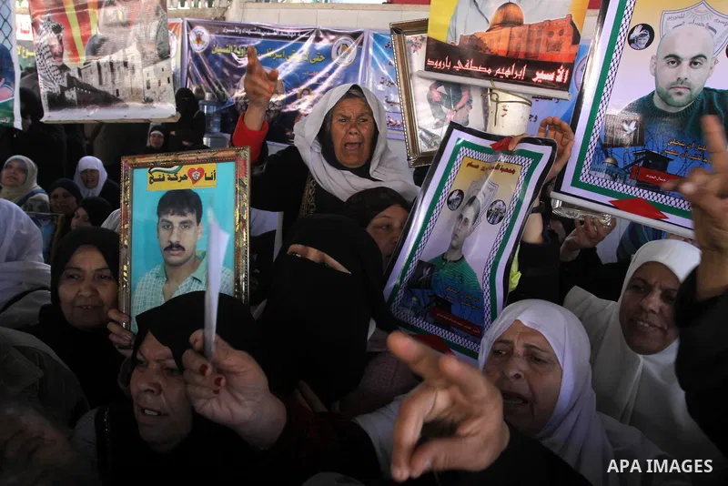 Palestinian women hold pictures of jailed relatives during a protest calling for the release of Palestinian prisoners from Israeli jails at the Red Cross office in Gaza City on Feb. 21, 2011. Photo by Mohammed Asad