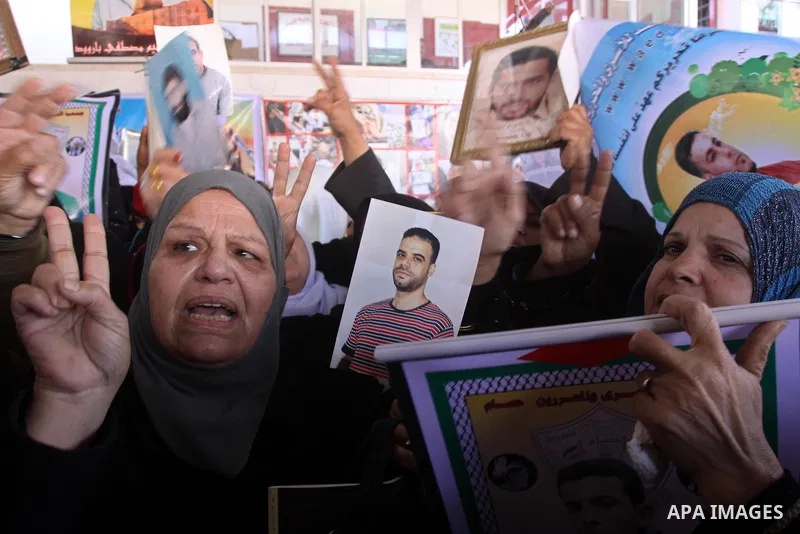 Palestinian women hold pictures of jailed relatives during a protest calling for the release of Palestinian prisoners from Israeli jails at the Red Cross office in Gaza City on Feb. 21, 2011. Photo by Mohammed Asad