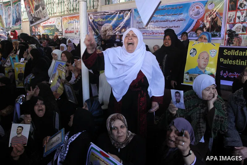 Palestinian women hold pictures of jailed relatives during a protest calling for the release of Palestinian prisoners from Israeli jails at the Red Cross office in Gaza City on Feb. 21, 2011. Photo by Mohammed Asad