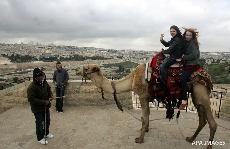 Foreign tourists ride a camel near the Dome of the Rock at the Al-Aqsa Mosque compound in Jerusalem on Feb. 21,2011. Photo by Mahfouz Abu Turk