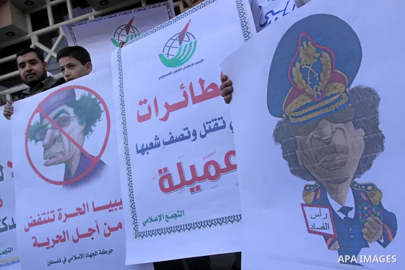 Palestinians hold up placards during a protest against Libyan leader Moamer Kadhafi in Gaza City on February 22, 2011. Gaza's Jihad Islamic rulers heaped condemnation on "the massacres" of anti-government protestors in L...