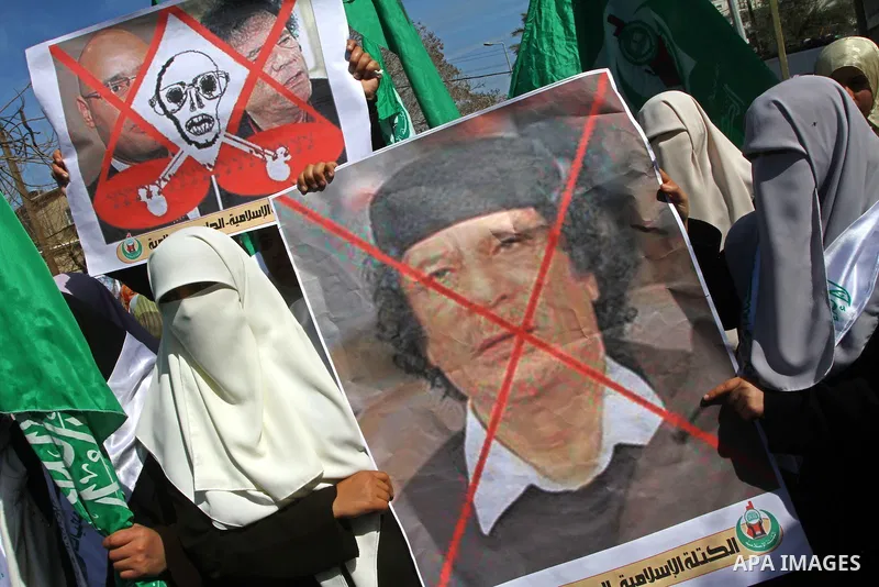 Palestinian students hold up placards during a protest against Libyan leader Moamer Kadhafi, in Gaza City on February 22, 2011. Gaza's Hamas rulers heaped condemnation on "the massacres" of anti-government protestors in...