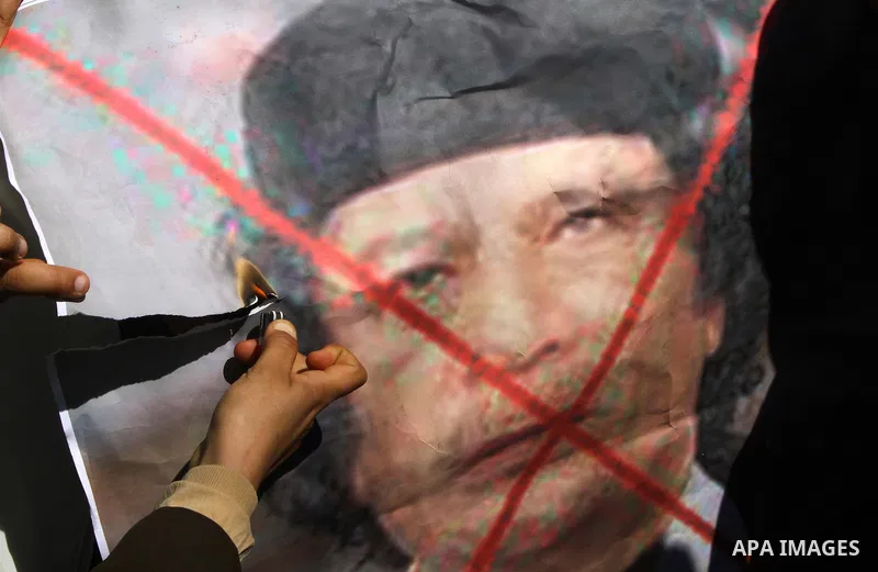 Palestinian students burn a poster of Libyan leader Moammar Gadhafi during a march in solidarity with Libya, in Gaza City, Tuesday, Feb. 22 , 2011. Gadhafi's 42-year rule is under unprecedented pressure from an uprising...