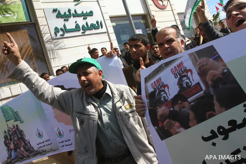 Palestinians hold up placards during a protest against Libyan leader Moamer Kadhafi, in Gaza City on February 22, 2011. Gaza's Hamas rulers heaped condemnation on "the massacres" of anti-government protestors in Libya co...