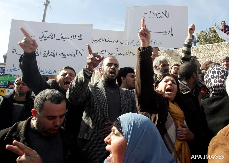Palestinians take part in a demonstration against the United States' recent veto in the UN Security Council dealing with Israeli settlements in the West Bank, as they protest at the Damascus Gate in East Jerusalem on 22...