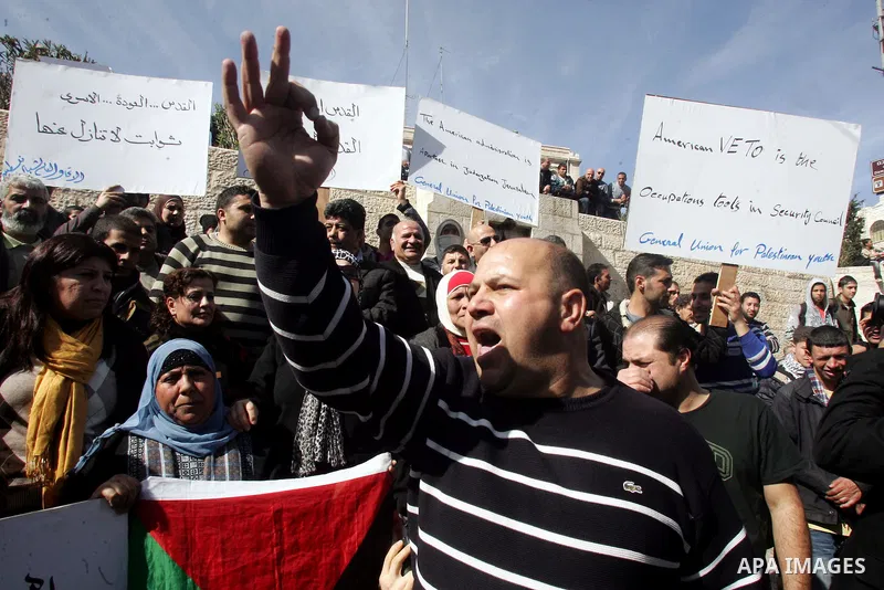 Palestinians take part in a demonstration against the United States' recent veto in the UN Security Council dealing with Israeli settlements in the West Bank, as they protest at the Damascus Gate in East Jerusalem on 22...