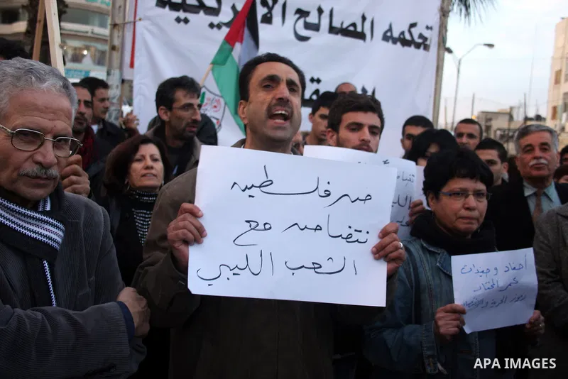 Palestinians hold up placards during a protest against Libyan leader Moamer Kadhafi,in the West Bank city of Ramallah on Feb. 22, 2011. Photo by Issam Rimawi