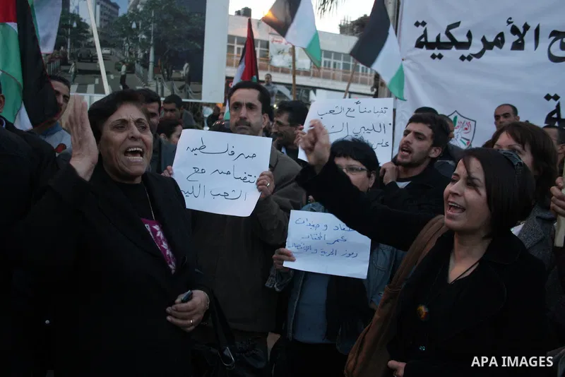 Palestinians hold up placards during a protest against Libyan leader Moamer Kadhafi,in the West Bank city of Ramallah on Feb. 22, 2011. Photo by Issam Rimawi