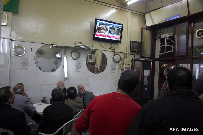 Palestinians inside the coffee watching on television the speech of Libyan leader Moamer Kadhafi, in the West Bank city of Ramallah on Feb. 22, 2011. Photo by Issam Rimawi