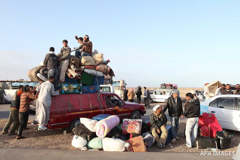 Egyptians, who have fled from Libya through the Salloum land port gate wait with their luggage,Tuesday, Feb. 22, 2011. An estimated 5,000 Egyptians have returned home from Libya by land, and about 10,000 more are waiting...
