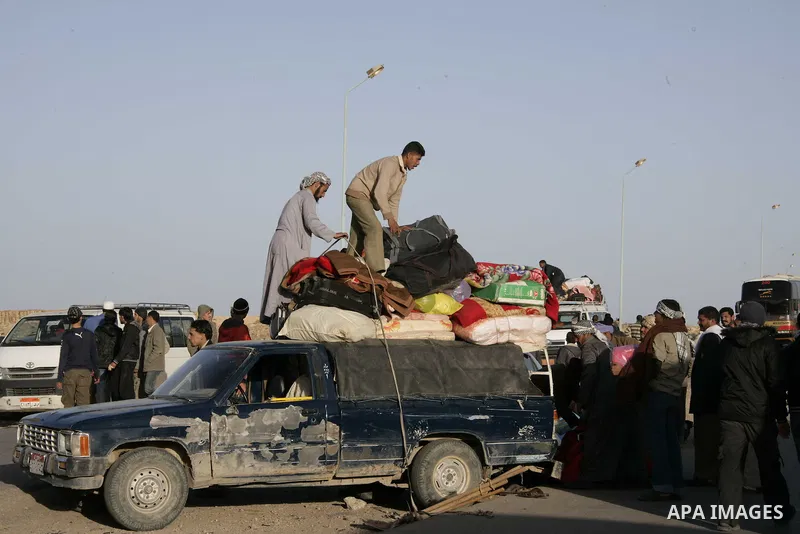 Egyptians, who have fled from Libya through the Salloum land port gate wait with their luggage,Tuesday, Feb. 22, 2011. An estimated 5,000 Egyptians have returned home from Libya by land, and about 10,000 more are waiting...