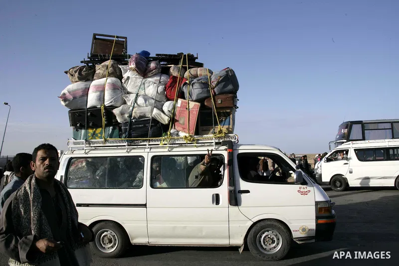 Egyptians, who have fled from Libya through the Salloum land port gate wait with their luggage,Tuesday, Feb. 22, 2011. An estimated 5,000 Egyptians have returned home from Libya by land, and about 10,000 more are waiting...