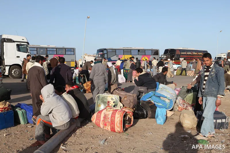 Egyptians, who have fled from Libya through the Salloum land port gate wait with their luggage,Tuesday, Feb. 22, 2011. An estimated 5,000 Egyptians have returned home from Libya by land, and about 10,000 more are waiting...