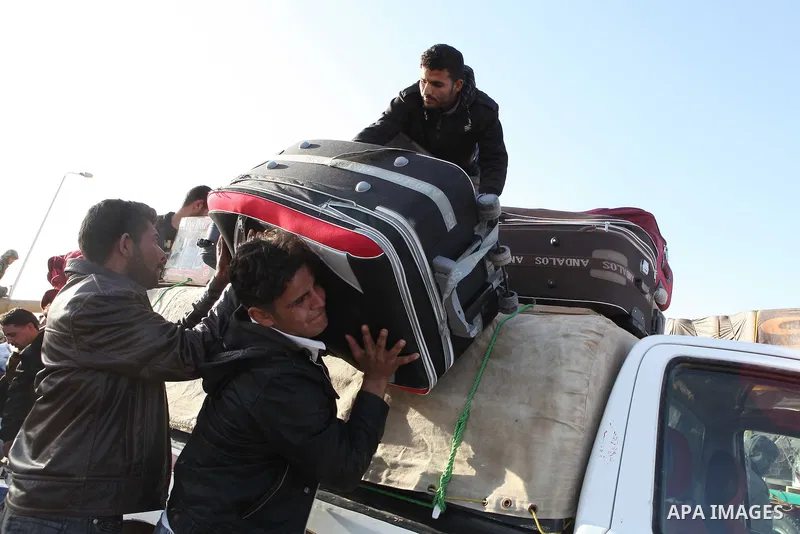 Egyptians, who have fled from Libya through the Salloum land port gate wait with their luggage,Tuesday, Feb. 22, 2011. An estimated 5,000 Egyptians have returned home from Libya by land, and about 10,000 more are waiting...