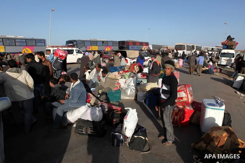 Egyptians, who have fled from Libya through the Salloum land port gate wait with their luggage,Tuesday, Feb. 22, 2011. An estimated 5,000 Egyptians have returned home from Libya by land, and about 10,000 more are waiting...
