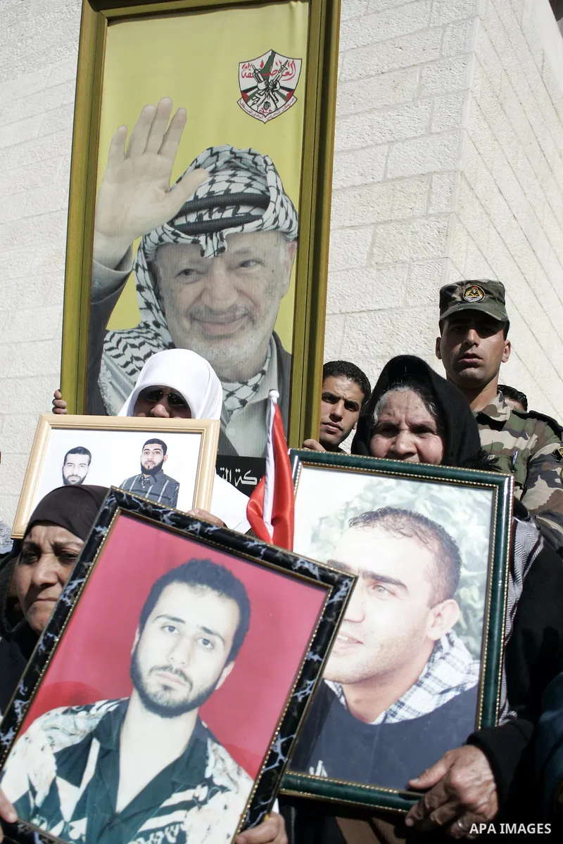 Palestinian protesters hold national flags and banners during a rally against the U.S. veto and calling for the national reconciliation in the West Bank city of Bethlehem, on Feb. 23, 2011. Photo by Najeh Hashlamoun