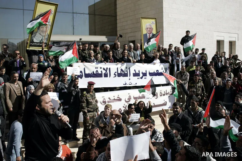 Palestinian protesters hold national flags and banners during a rally against the U.S. veto and calling for the national reconciliation in the West Bank city of Bethlehem, on Feb. 23, 2011. Photo by Najeh Hashlamoun