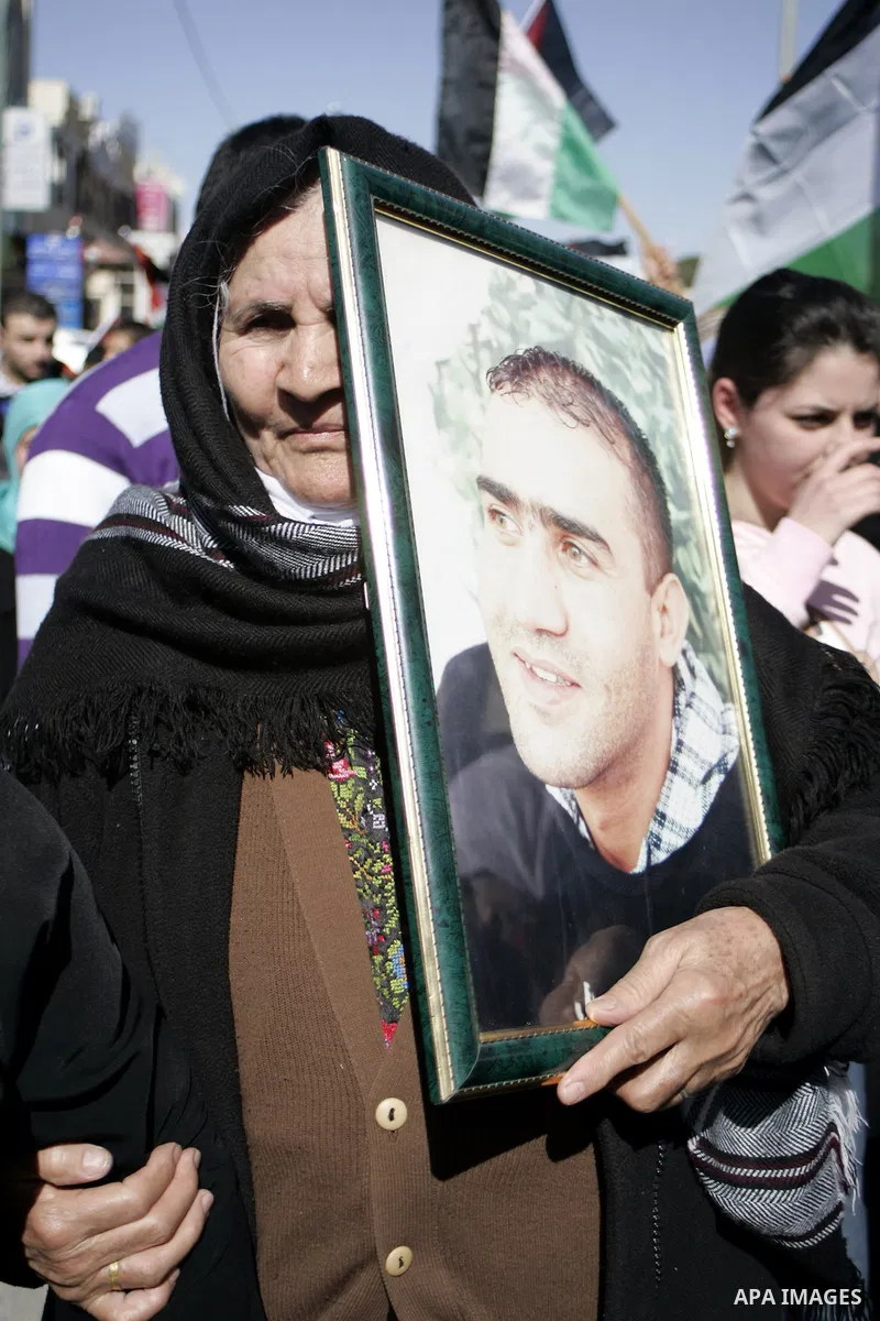 Palestinian protesters hold national flags and banners during a rally against the U.S. veto and calling for the national reconciliation in the West Bank city of Bethlehem, on Feb. 23, 2011. Photo by Najeh Hashlamoun